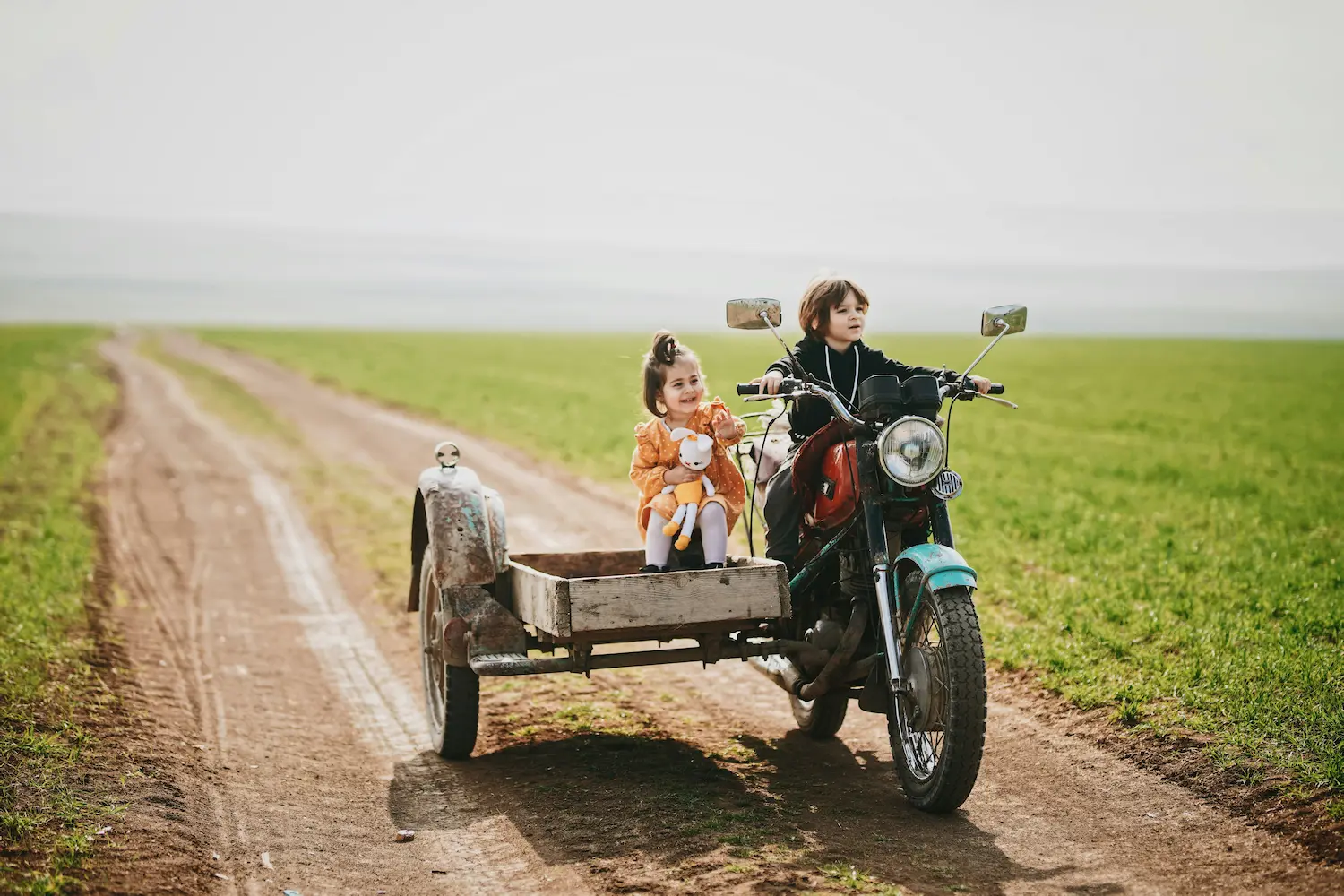 Image de fond montrant deux enfants heureux sur un side-car
